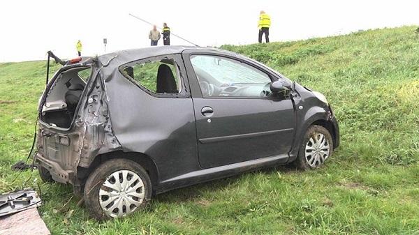 Auto vliegt over de kop bij afrit snelweg; bestuurder gewond