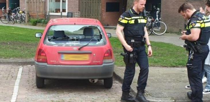 Groep kinderen ( 5-8 jaar ) vernielen raam van auto