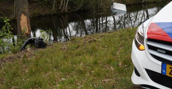 Busje botst tegen boom en raakt te water