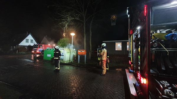 Brandweer blust brandende kledingcontainer