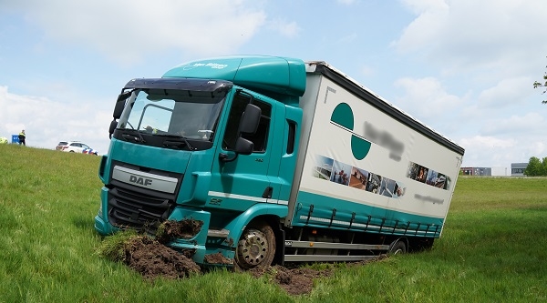 Vrachtwagen schiet van de N34 af en komt onder aan talud terecht (video)