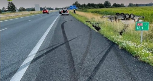 Aanhanger beladen met auto schiet los van auto en schiet van de snelweg af