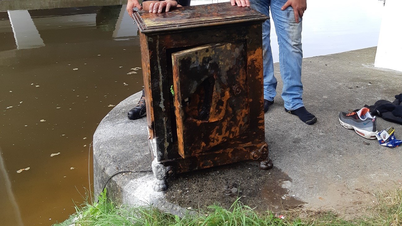 Magneetvissers halen met politie kluis uit het water en brengen hem naar eigenaar