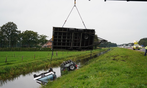 Auto met autotransporter beladen met auto te water langs A28