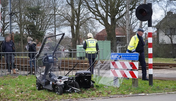 Scootmobiel valt stil op spoor en botst met trein