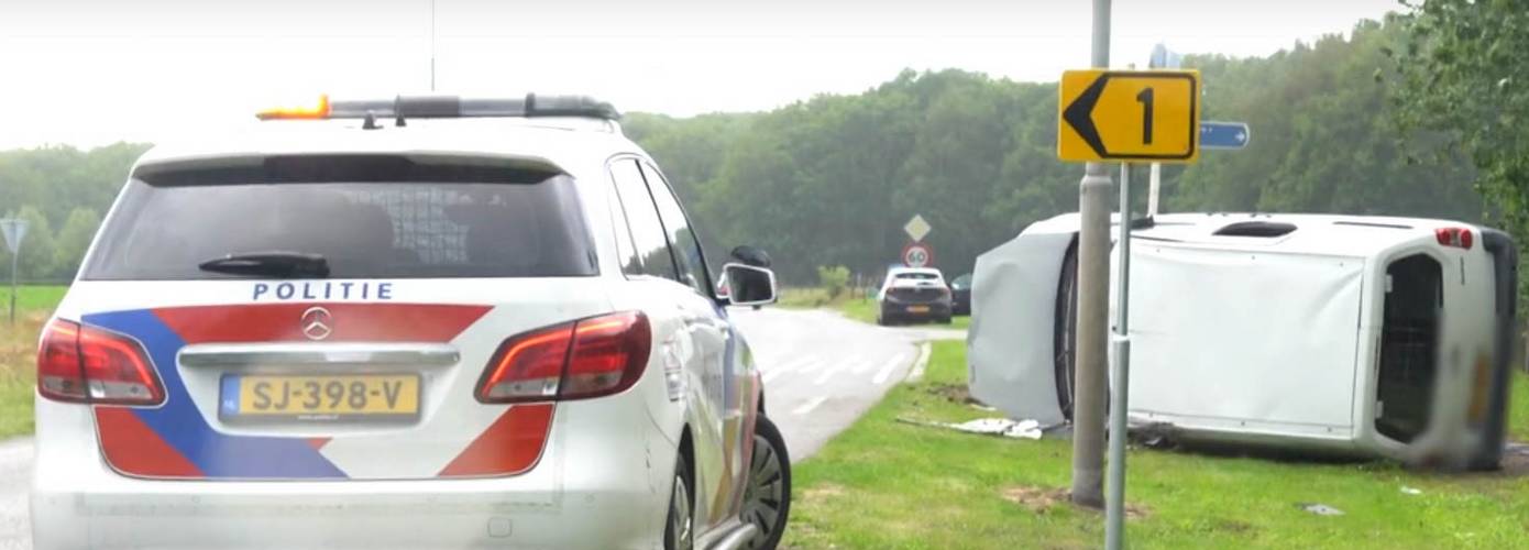 Busje op de kant na botsing met auto (video)