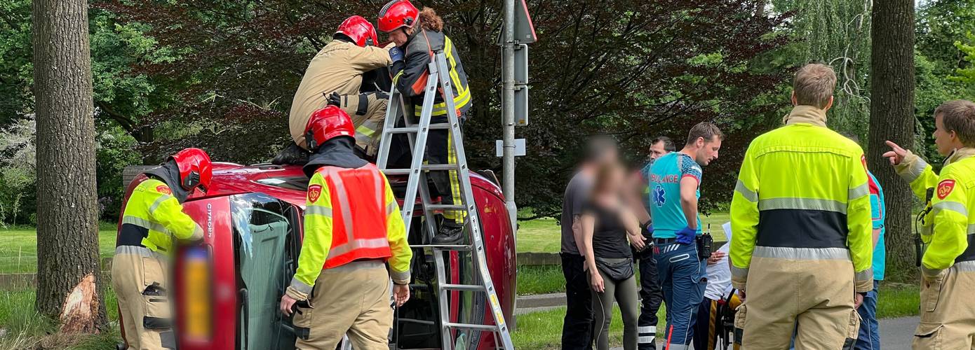 Auto op de kant na botsing met middengeleider