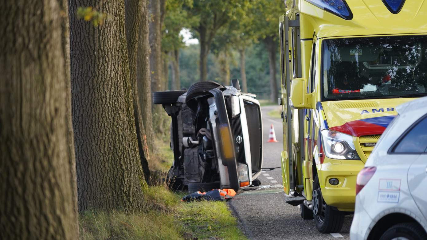 Auto op de kant na botsing tegen boom (video)