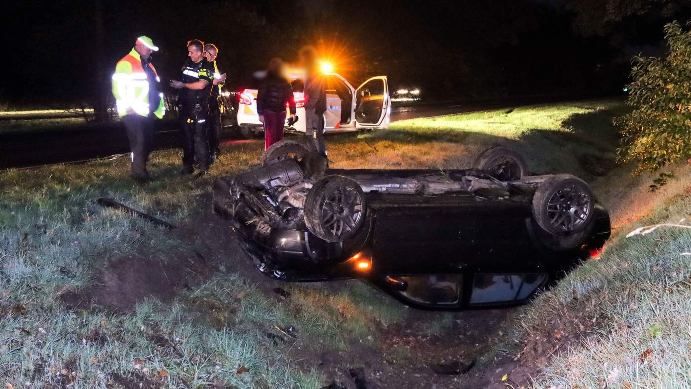 Auto met twee inzittenden vliegt over de kop in Emmen