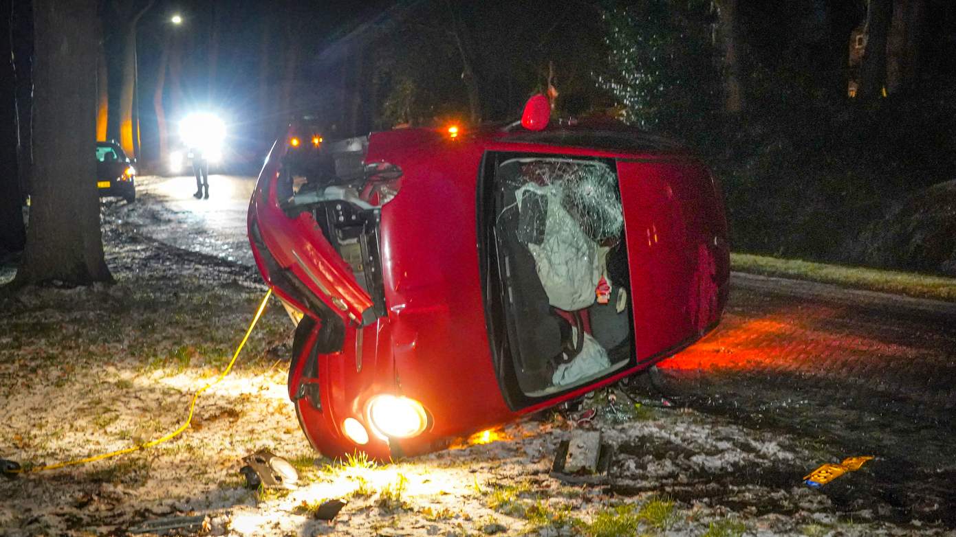 Auto op de kant na botsing met paaltje door gladheid