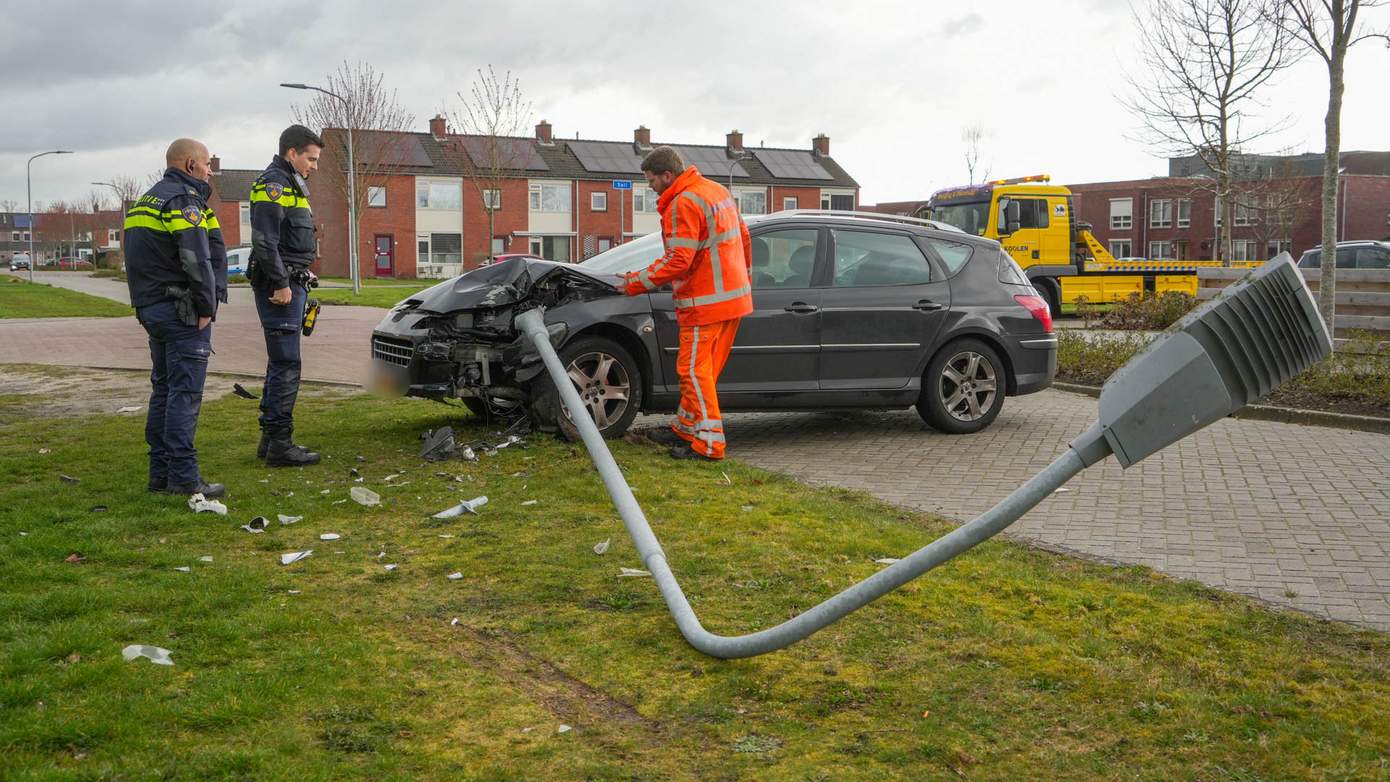 Auto rijdt zich vast op lantaarnpaal na botsing met andere auto