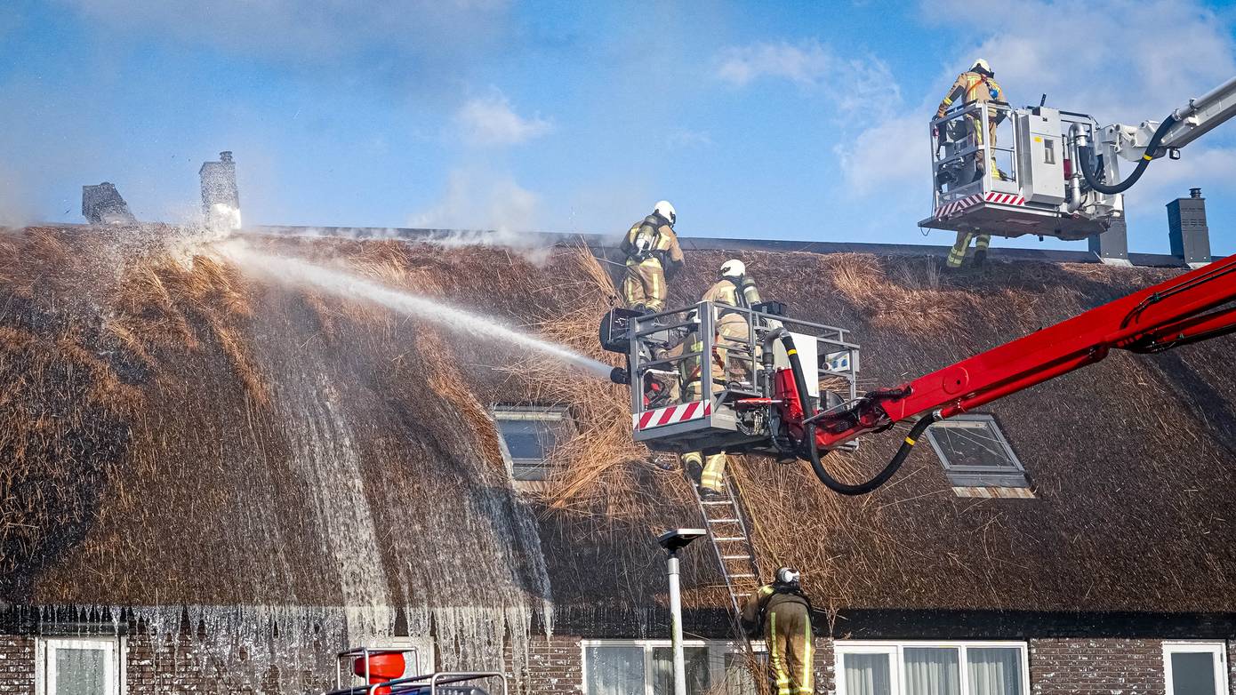 Grote uitslaande brand in rieten dak van rijtjeshuizen (Video)