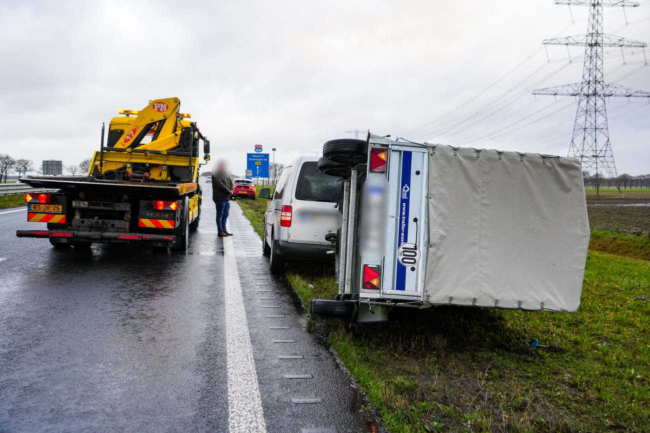 Aanhanger op zijn kant door harde wind op N34