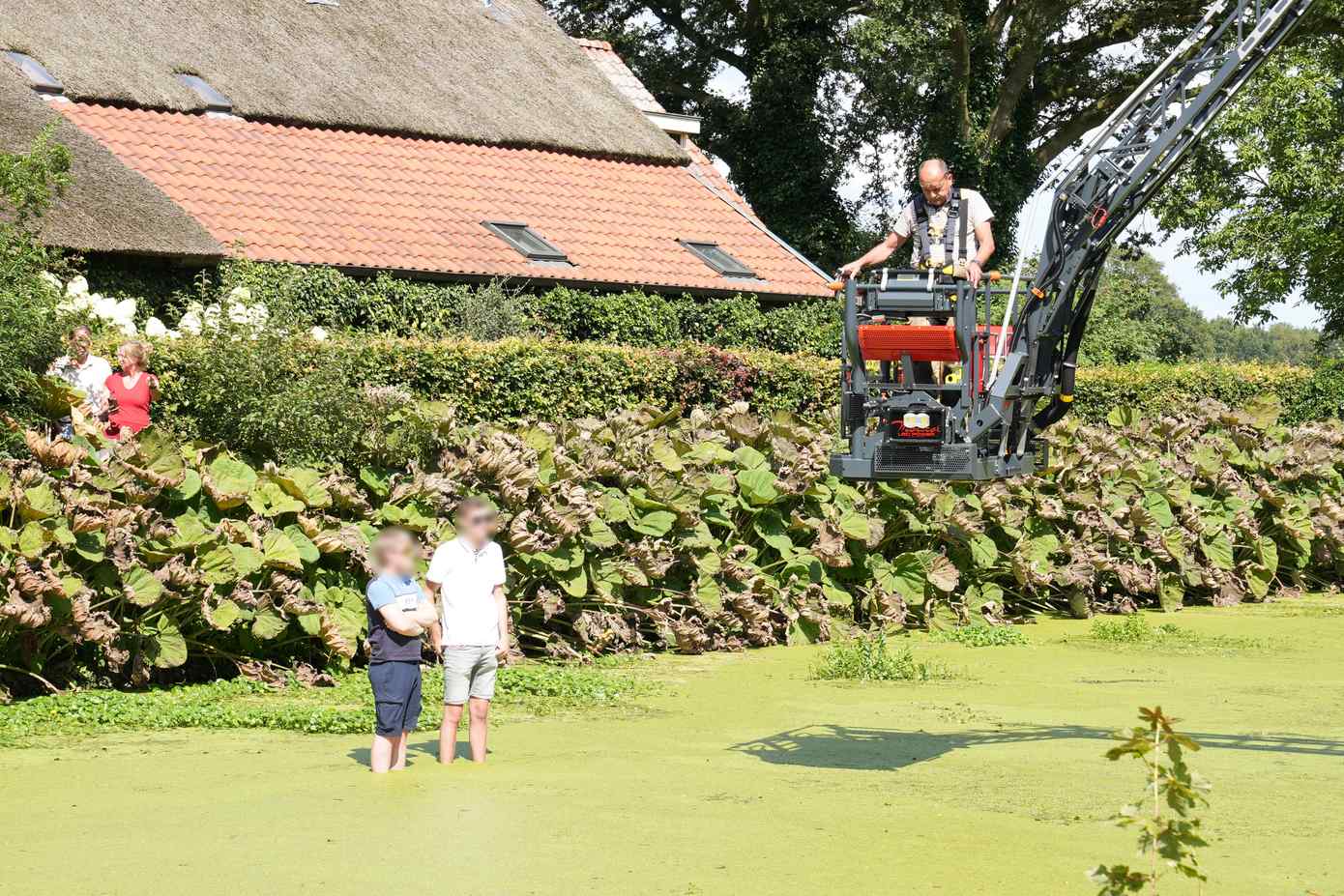 Auto met twee inzittenden raakt te water; brandweer redt inzittenden met hoogwerker