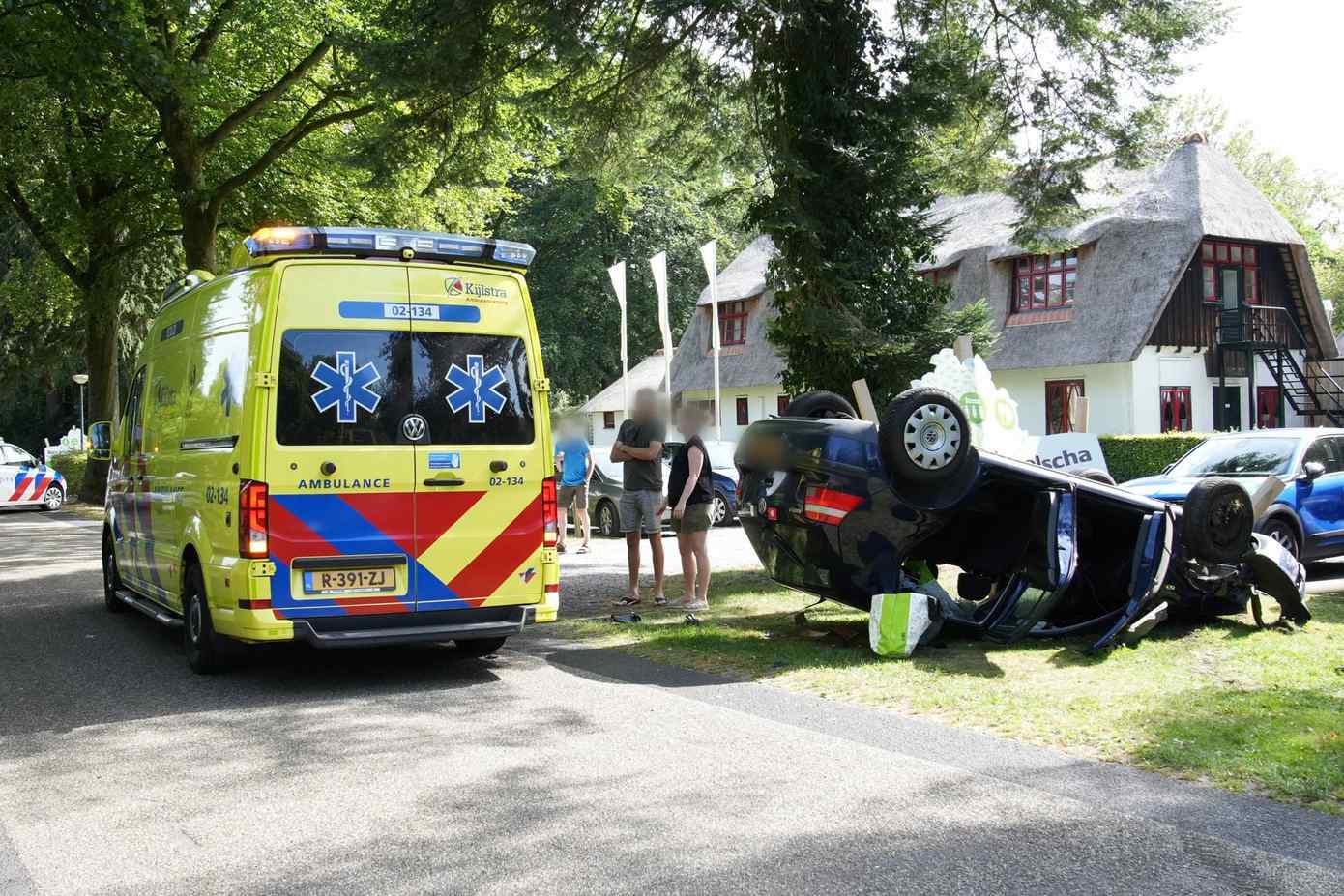 Auto belandt op het dak na botsing met andere auto en paaltje