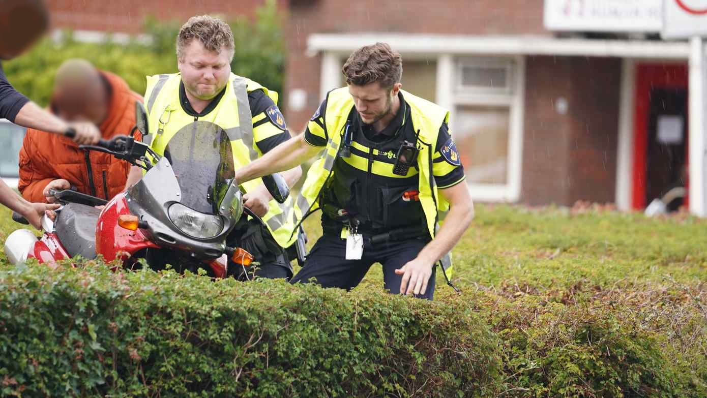 Motorrijder schiet rechtdoor de bosjes in op nat wegdek