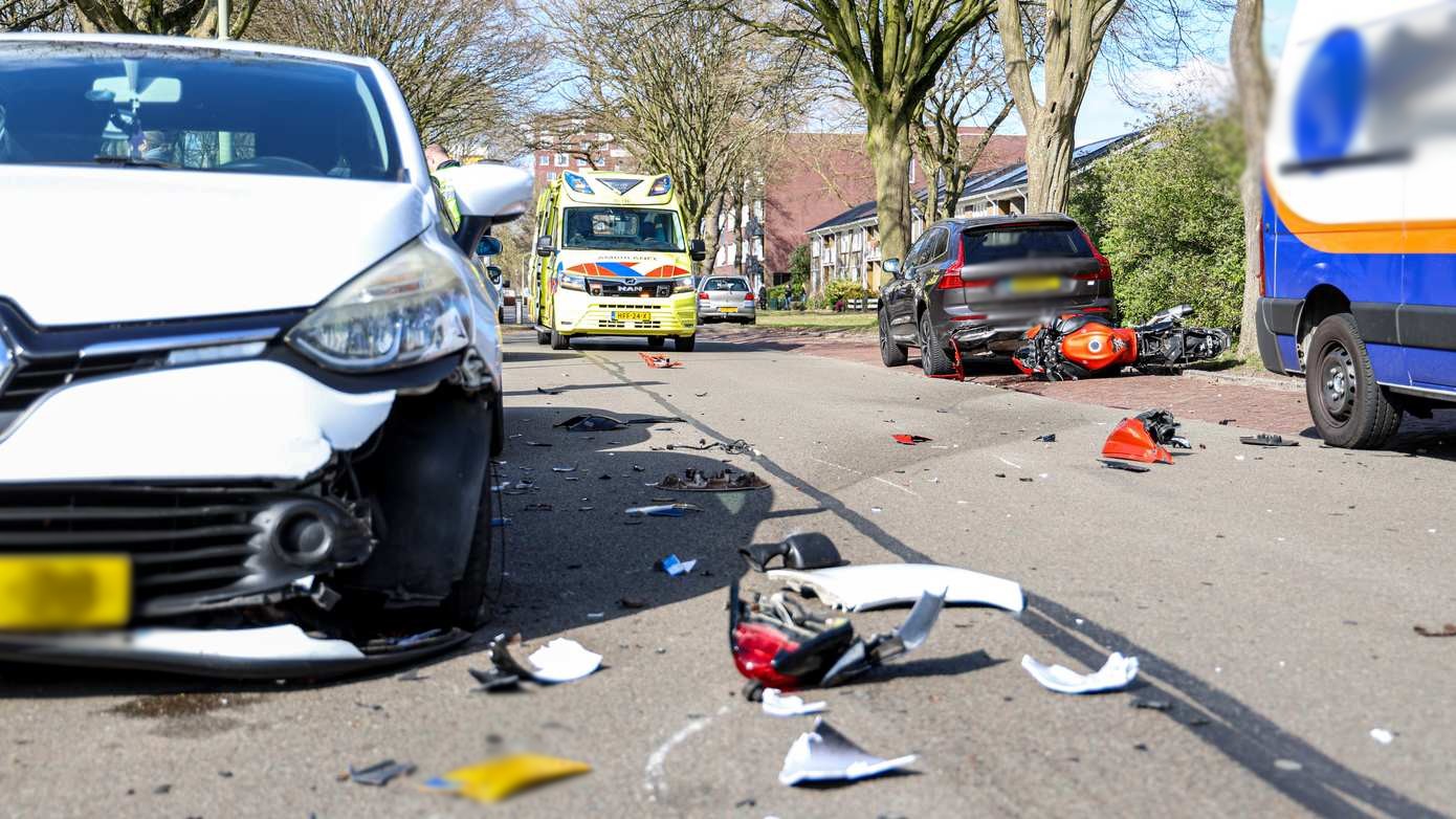 Motorrijder gelanceerd na botsing met twee geparkeerde auto's